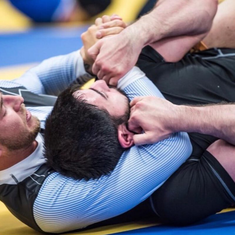Professor Cody MacCharles controlling an opponent during a no-gi Brazilian Jiu-Jitsu competition match.