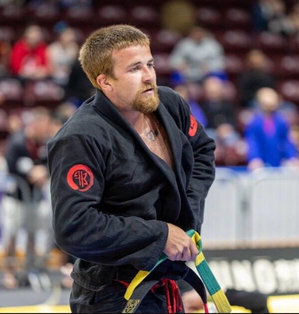 Professor Cody MacCharles competing in a black gi during a Brazilian Jiu-Jitsu tournament.