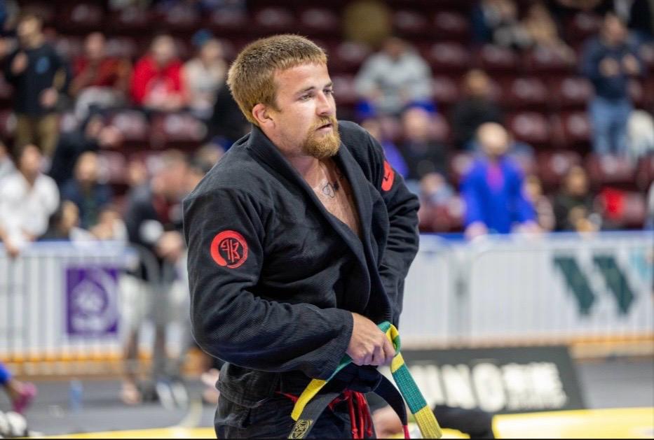 Professor Cody MacCharles competing in a black gi during a Brazilian Jiu-Jitsu tournament.