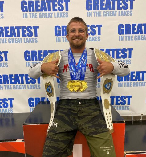 Cody MacCharles with BJJ Championship Belts and Medals Cody MacCharles displaying Brazilian Jiu-Jitsu championship belts and gold medals after competition.