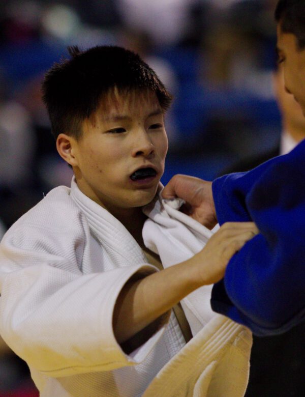 Sensei Connor Lau grip-fighting with an opponent during a competitive Judo match.