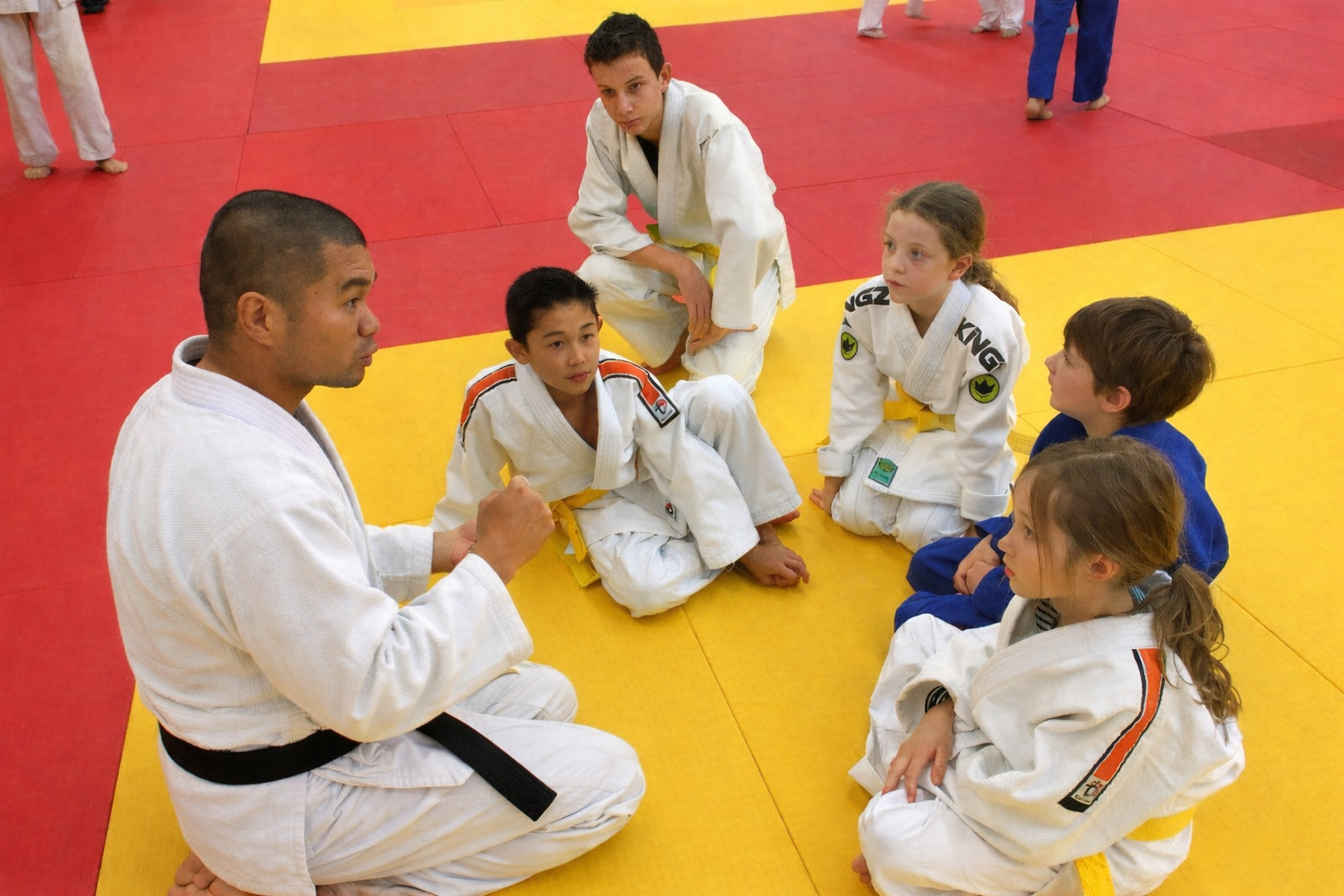 Sensei Kevin Coaching Youth Judo Athletes Sensei Kevin giving instructions to a group of young Judo athletes during a tournament.