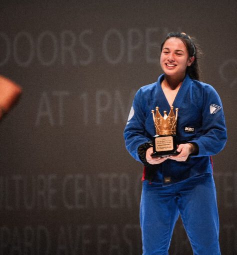 Professor Shiv Barnes – BJJ Superfight Champion Professor Shiv Barnes smiling while holding a championship trophy after a Brazilian Jiu-Jitsu superfight.