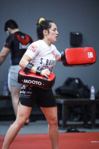Professor Shiv Barnes holding kickboxing pads during a striking training session.