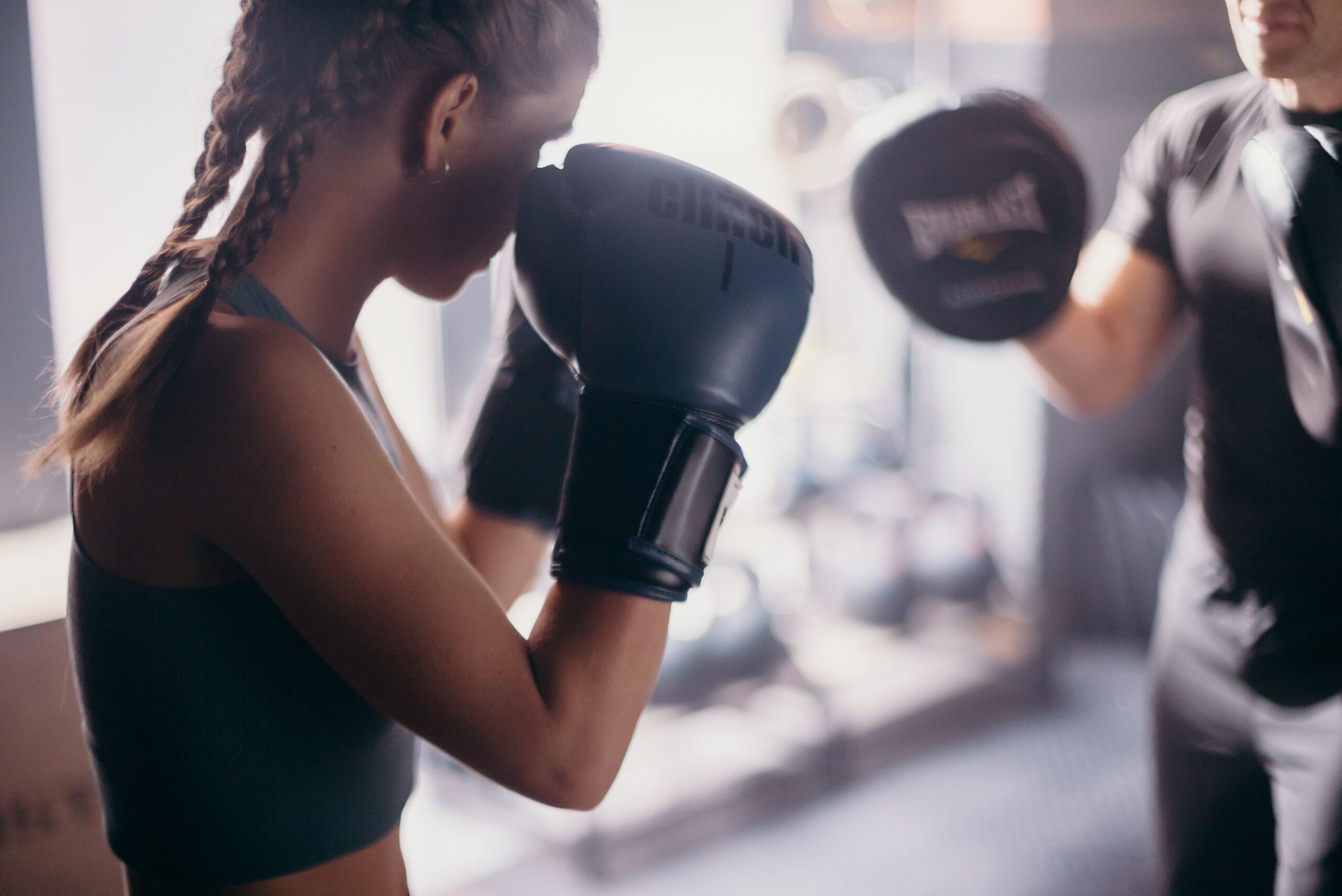 Kickboxing Pad Training in Newmarket A kickboxing student practising punches with a coach holding focus mitts.