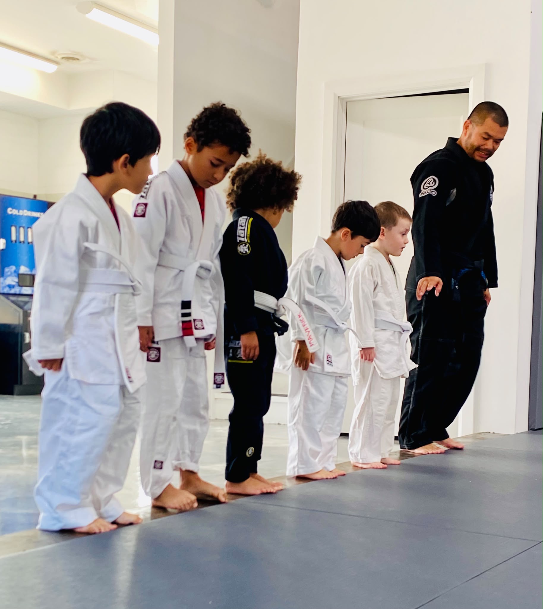 Kids training Brazilian Jiu-Jitsu with an instructor at True North Martial Arts in Newmarket, Ontario.